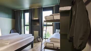 A bunk bed room with a desk, a chair, and a window with curtains.