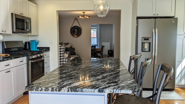 A modern kitchen with a marble countertop, stainless steel appliances, and a chandelier. - Luxury living, quick walk to town. King bed. (Eastport)