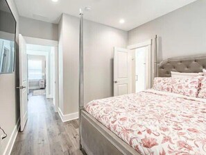 Une chambre à coucher comprenant un lit, une armoire et une porte donnant sur une salle de bain.