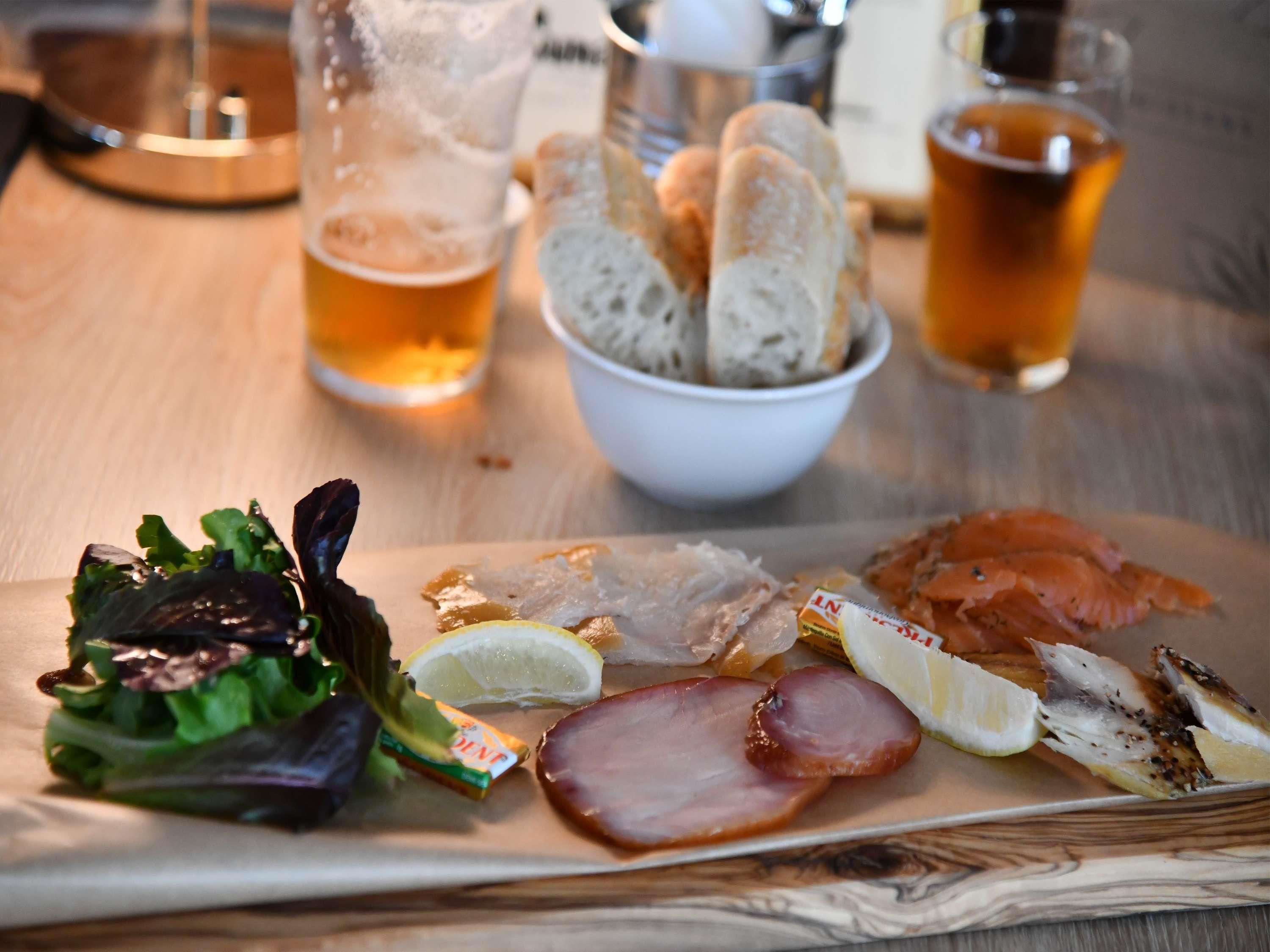 Un repas composé de différents plats et boissons, servis sur une table en bois.