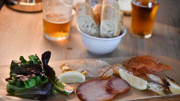 Una comida con diferentes platos y bebidas sobre una mesa de madera.