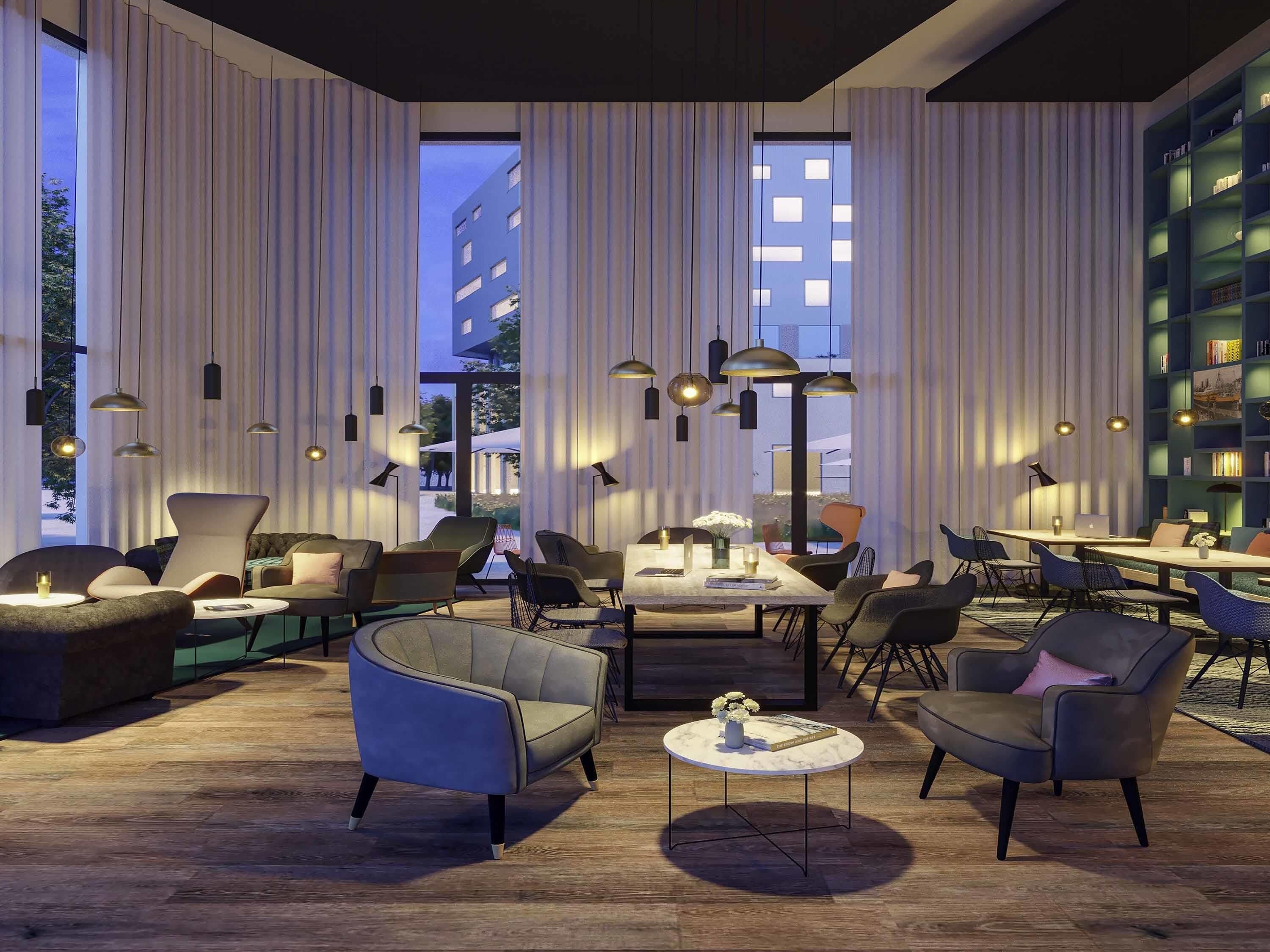 A modern lounge area with a large window, multiple seating options, and a bookshelf.