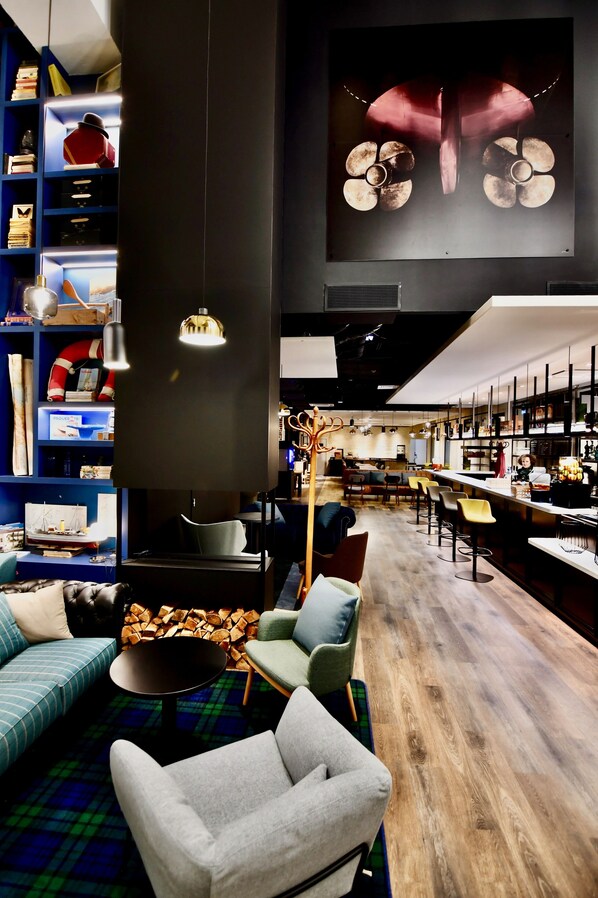 Un interior moderno con una zona de bar, asientos y una obra de arte grande en la pared.