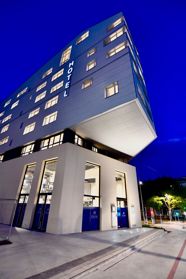 Un hôtel moderne doté d’un toit plat, de plusieurs étages et de grandes fenêtres.