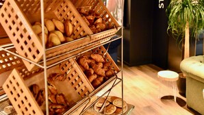 A bakery display with various baked goods in wicker baskets. - Ibis Budget Saint Nazaire Centre Gare (Saint-Nazaire)