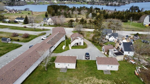A residential area with detached houses, a paved road, and a body of water in the background. - NEW AGE MOTEL INN (Yarmouth)