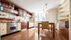 Una cucina moderna con mobili in legno, elettrodomestici in acciaio inossidabile e un'area pranzo con tavolo e sedie.