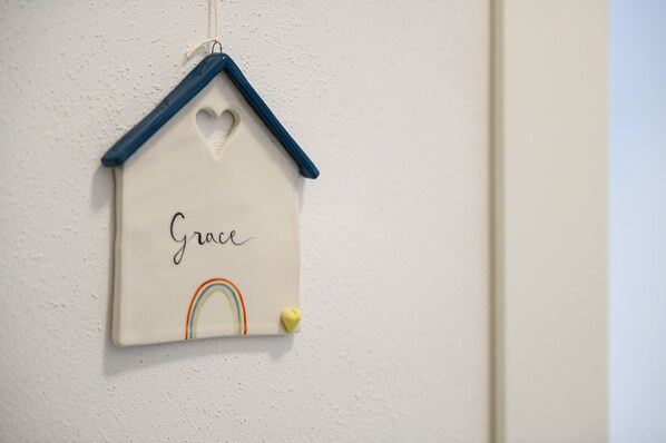 A wall-mounted decoration with a heart-shaped cutout and the word "Grace" written on it.