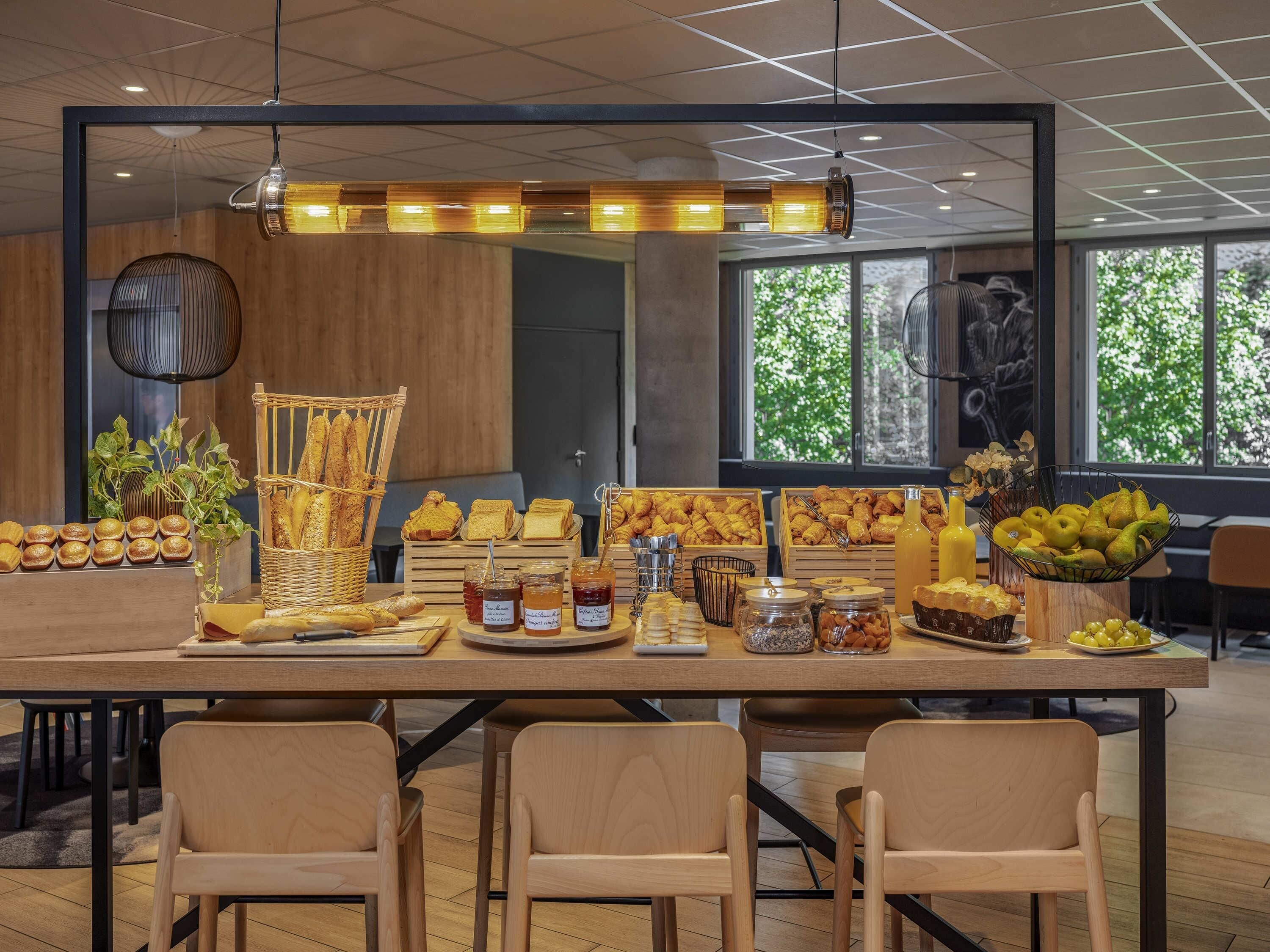 A breakfast buffet with various pastries, bread, and fruits.