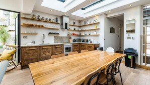 A modern kitchen with wooden cabinets, a large island, and built-in shelves.
