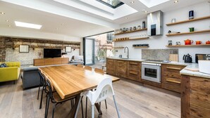 A modern kitchen with wooden cabinets, a built-in oven, and a large island with seating.
