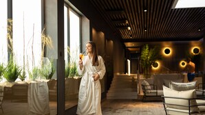 A modern interior with a glass wall, indoor plants, and a seating area with a sofa and chairs. - Meri Hotel & SPA (Kuressaare)