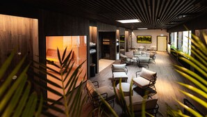 A modern interior with wooden walls, a central seating area with cushioned chairs, and a large window on the right. - Meri Hotel & SPA (Kuressaare)