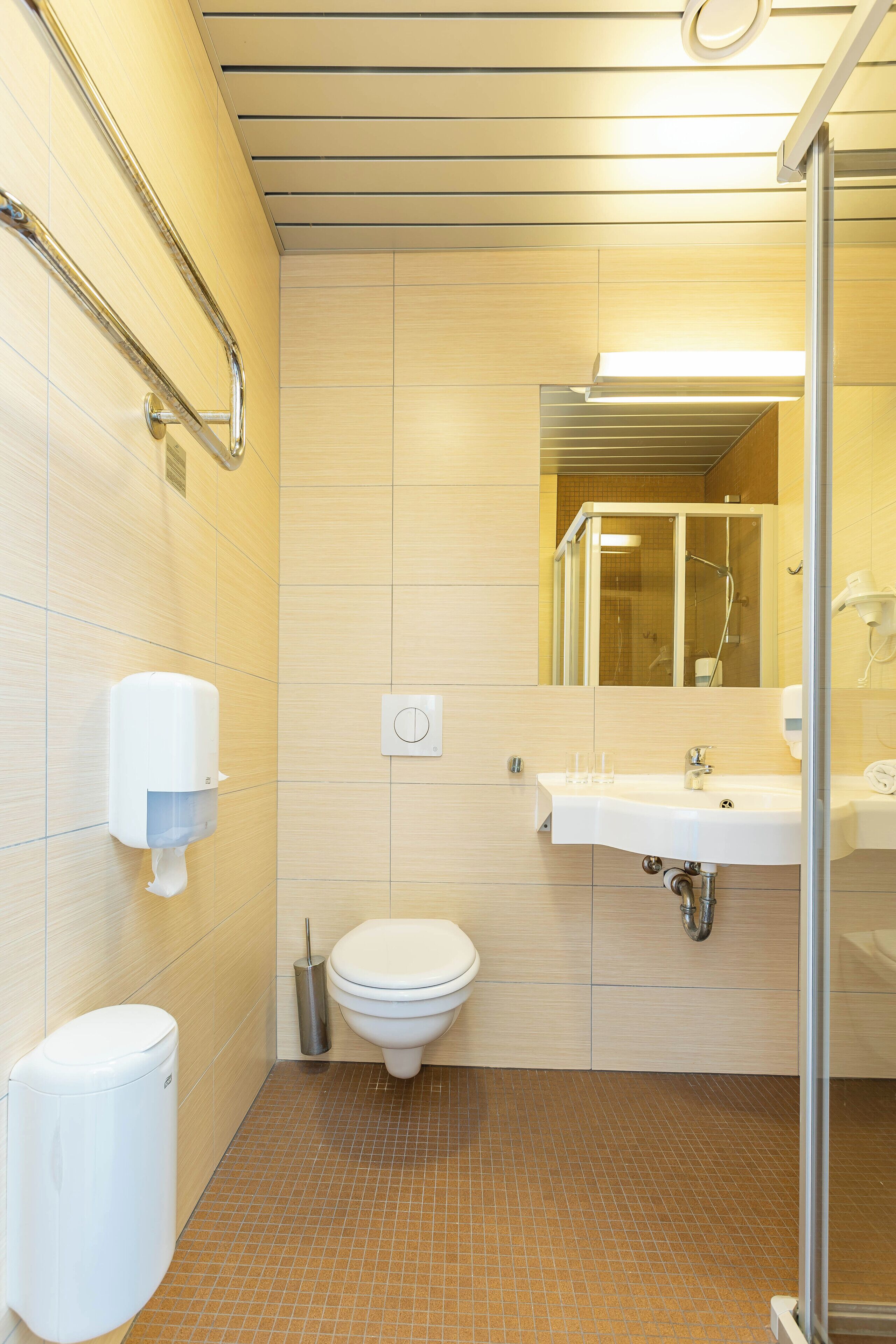 A modern bathroom with a toilet, sink, and shower.