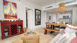 A modern living room with a dining area, a kitchen, and a large mirror. - Coastal Retreat 2BR Skyline Marina View (Río Hato)