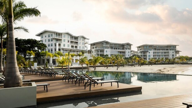 Ein Resort mit Pool, Liegestühlen und Strand.
