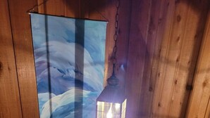 A wooden interior with a painting of a bird and a hanging lantern. - Peaceful Cavalier Townhome #2 Near Lake Owen (Cable)