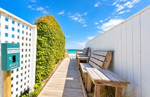 A wooden pathway leading to beachside seating with a 'please clean up after your dog' sign. - The Pup Deck - Duck, Carolina Dunes, 420 Yds to Beach, Pool, Hot Tub, Pets OK, Flex Stays (Duck)
