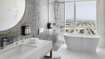 A modern bathroom with a large bathtub, a shower, and a vanity with a mirror.