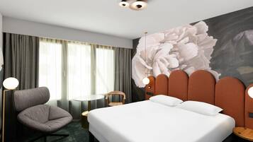 Une chambre d’hôtel avec un grand lit, une chaise, une petite table et un mur orné d’une fresque florale.