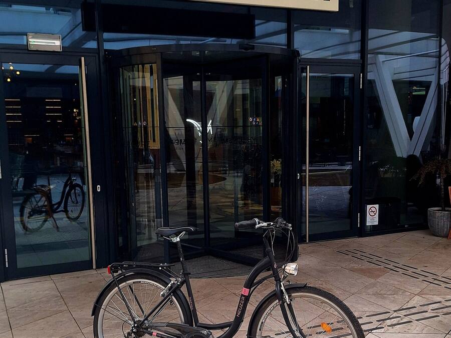 Entrada de un Hotel Mercure con una bicicleta estacionada frente a él.