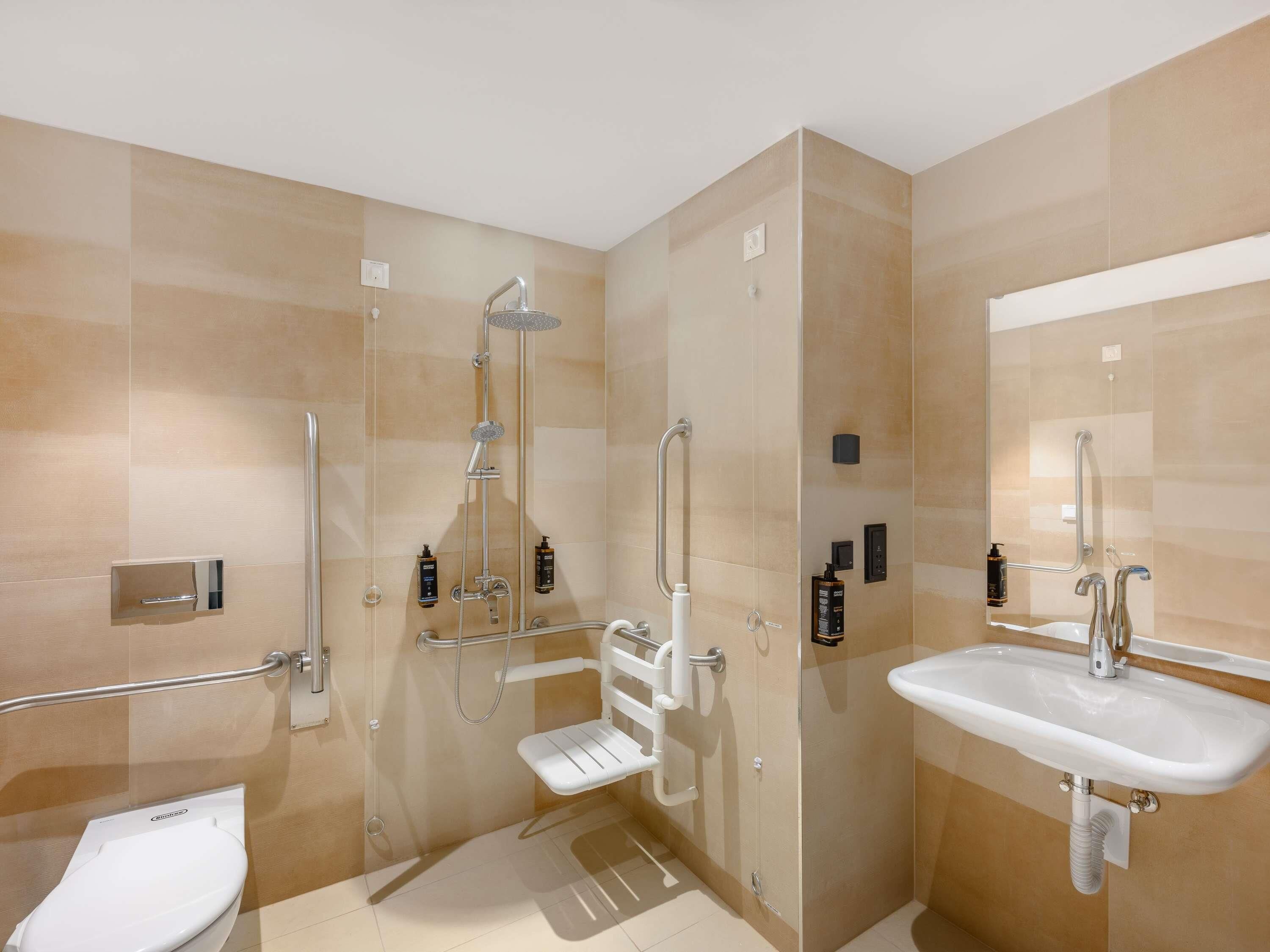 Une salle de bain moderne avec une douche à l’italienne, des toilettes et un lavabo.