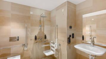 Une salle de bain moderne avec une douche à l’italienne, des toilettes et un lavabo.