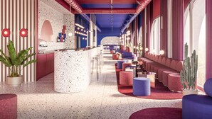 Moderni hotellin aula, jossa on keskeisellä paikalla sijaitseva baari, oleskelualueita ja suuret ikkunat.