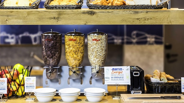 A breakfast buffet with various cereals, fruits, and pastries. - Ibis Budget Reims Parc Des Expositions (Reims)