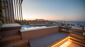 Eine Dachterrasse mit Pool, Holzstufen und einer Sitzbank.
