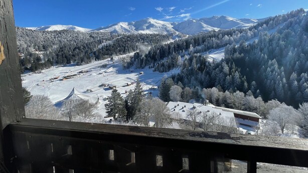 A mountain landscape with snow-covered slopes and a ski resort in the valley. - T2 avec une vue imprenable sur la station du Liora (Le Lioran)