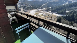 A balcony with a view of a valley, mountains, and a river. - T2 avec une vue imprenable sur la station du Liora (Le Lioran)