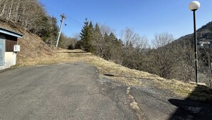 A rural road with a small building on the left and a street lamp on the right. - T2 avec une vue imprenable sur la station du Liora (Le Lioran)