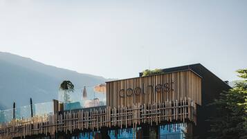 Un edificio moderno con fachada de madera y el nombre 'cool nest' a la vista.