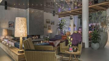 A modern living room with a fireplace, comfortable seating, and decorative lighting.
