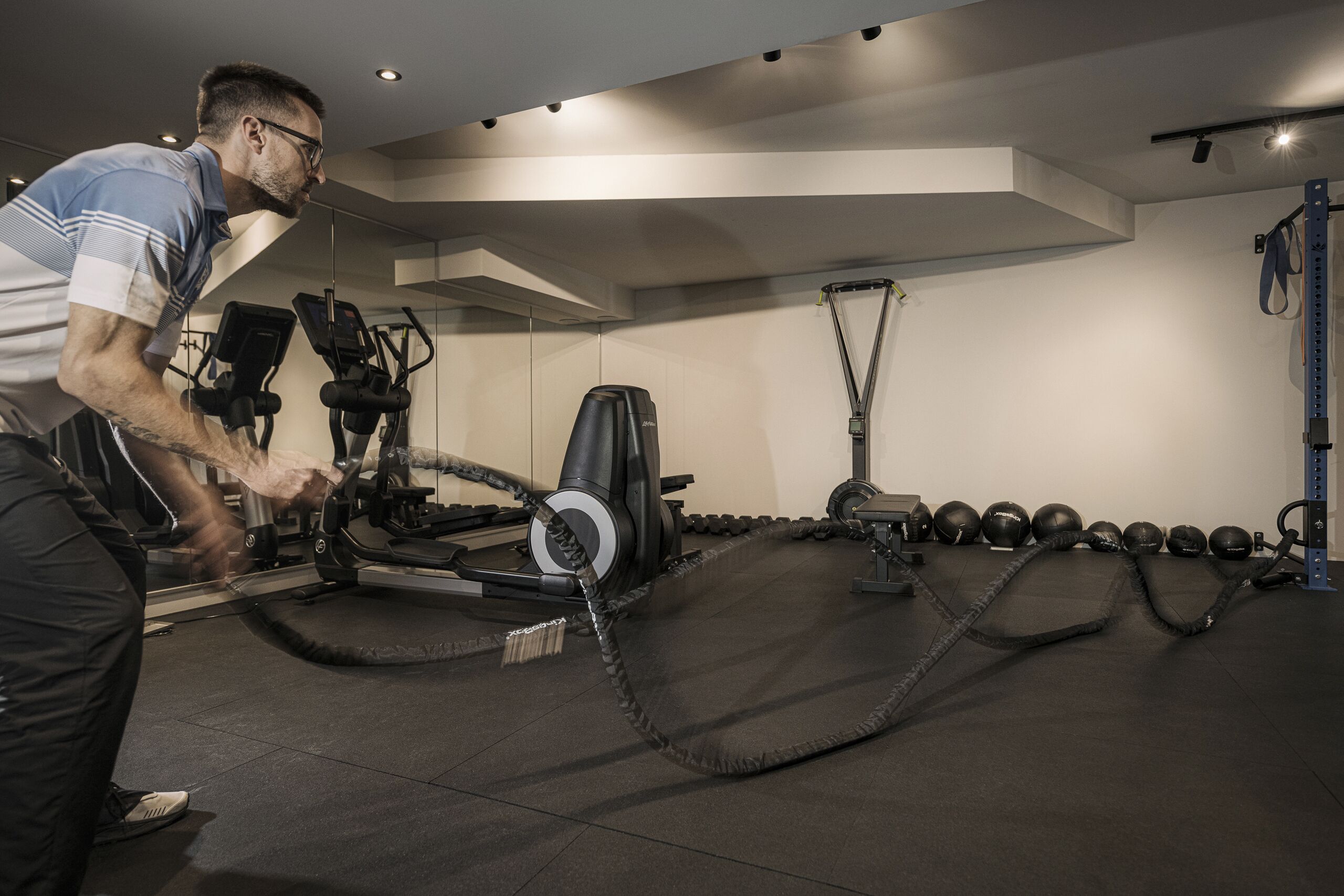 Una palestra con attrezzature per esercizi, tra cui tapis roulant e pesi.