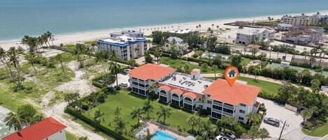 A coastal hotel with a pool, beachfront view, and multiple buildings.