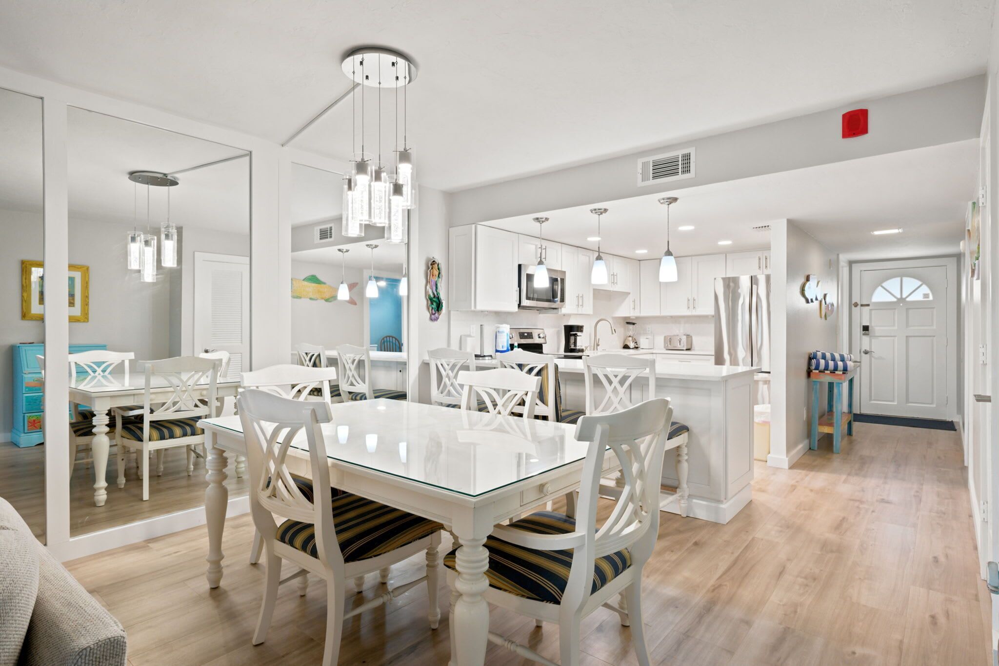 A modern kitchen with white cabinetry, a central island, and pendant lighting.