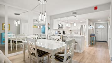 A modern kitchen with white cabinetry, a central island, and pendant lighting.