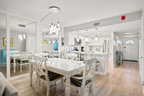 A modern kitchen with white cabinetry, a central island, and pendant lighting.