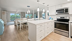 A modern kitchen with white cabinetry, stainless steel appliances, and pendant lighting. - Breakers West B3 | Stunning and Spacious West Gulf Drive Residence | Steps to Beach (Sanibel)