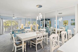 A dining area with a white table and chairs, a ceiling fan, and a view of the outdoors. - Breakers West B3- Stunning and Spacious West Gulf Drive Residence (Sanibel)