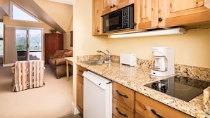 A kitchen with wooden cabinets, a microwave, a coffee maker, and a dishwasher. - Blue Mesa Lodge 32A by AvantStay | Located In The Heart Of Mountain Village (Telluride)