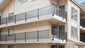 Un edificio de varios pisos con un cartel que dice 'Boomerang Village'. Cuenta con balcones con barandas negras y ventanas grandes.