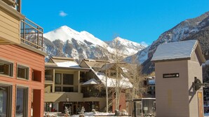 A hotel with multiple floors, a snow-covered mountain in the background, and a sign for 'Coonskin Lift'.
