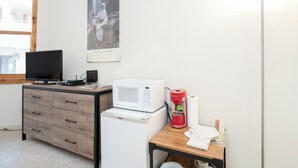 Une petite cuisine équipée d’un micro-ondes, d’un grille-pain et d’une machine à café, le tout posé sur une table en bois.