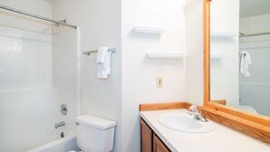 Une salle de bain équipée d’une baignoire, de toilettes, d’un lavabo et d’un miroir.
