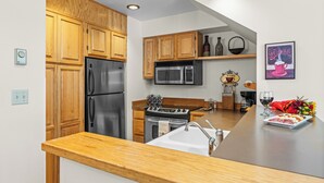 Una cocina moderna con armarios de madera, electrodomésticos de acero inoxidable y encimera de madera.