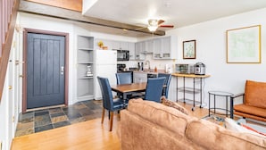 A modern kitchen with white cabinets, a dining table with blue chairs, and a ceiling fan. - Columbia Place 5 by AvantStay | Ski-In/Ski-Out Unit in Great Location! (Mountain Village)