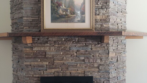 A stone fireplace with a framed picture above it. - Mountain View Retreat - on 5 private acres only 6 miles from Ohiopyle (Mill Run)